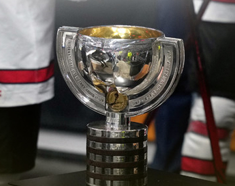 На изображении представлен серебряный трофей с золотистой внутренней частью на черной гладкой подставке. Кубок имеет массивный и современный дизайн, окружен выгравированными надписями